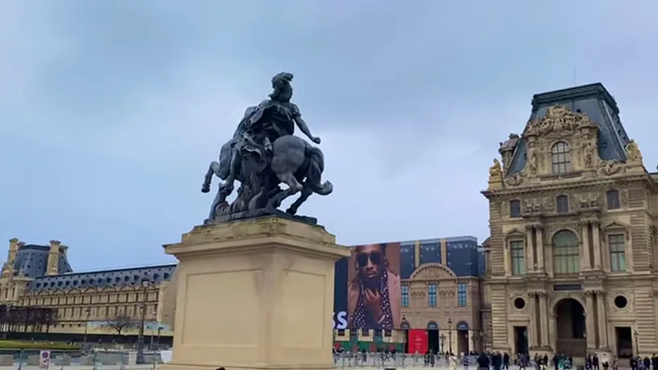 Equestrian statue in Louvre courtyard with palace buildings behind