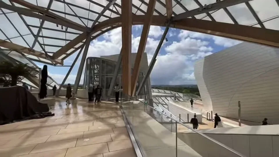 Sunlit stair corridor with visitors inside Fondation Louis Vuitton