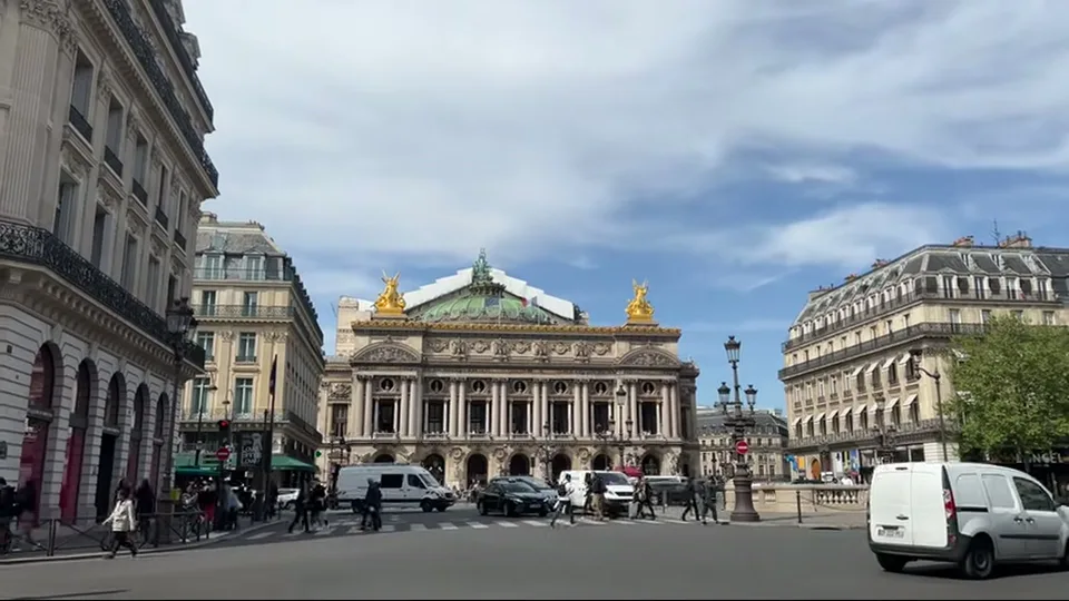 Symmetrical Paris boulevard view from Palais Garnier with crosswalks and crowds