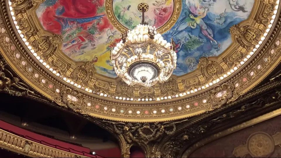 Gilded fireplace with caryatid statues and painted arch inside Palais Garnier